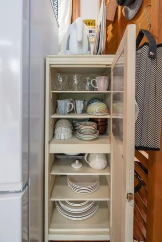 a cabinet filled with plates and dishes in a refrigerator at COCOTIER Enjoy a Free and Easy BBQ at a Cool Villa in Izu Best of Vacation Rentals 4 in Izunokuni