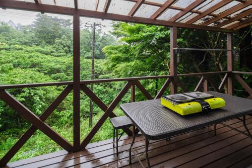 a yellow suitcase sitting on a table on a deck at COCOTIER Enjoy a Free and Easy BBQ at a Cool Villa in Izu Best of Vacation Rentals 4 in Izunokuni