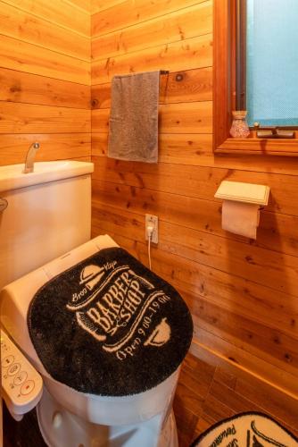 a bathroom with a toilet with a wooden wall at COCOTIER Enjoy a Free and Easy BBQ at a Cool Villa in Izu Best of Vacation Rentals 4 in Izunokuni
