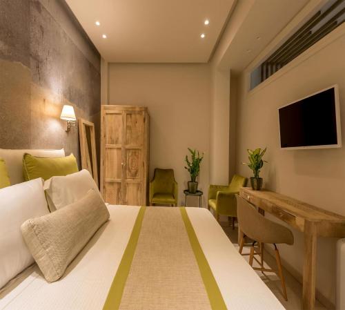 a bedroom with a bed and a desk and a television at Luxury Santorini Villa 4 Bedroom Villa Secluded Location & Private Pool Megalochori in Megalokhori