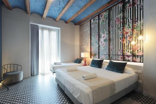 a bedroom with a large bed and a large window at YOU & CO. Quart Boutique in Valencia