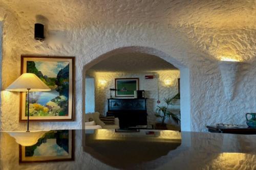 a living room with an archway and a living room with a television at Hotel Don Diego in Porto San Paolo