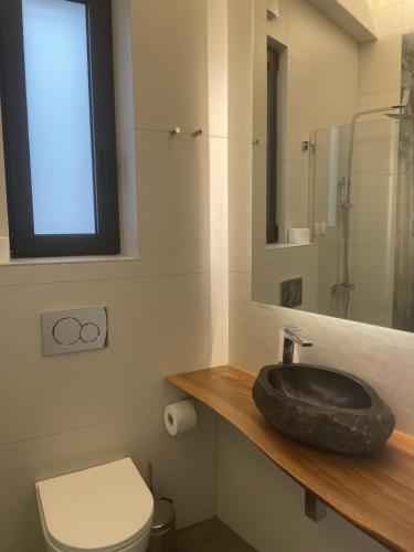 a bathroom with a black sink and a toilet at Nõs Luxury Rooms in Mesolongion