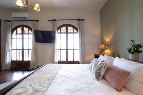 a bedroom with a large white bed with two windows at The Summit Escape House in Achílleion