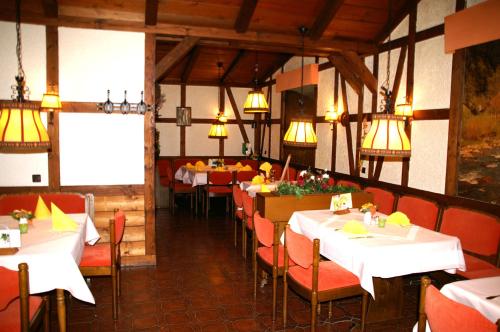 ein Esszimmer mit Tischen, Stühlen und Lampen in der Unterkunft Hotel Restaurant Bieberstuben in Menden