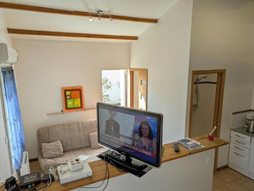 un salon avec une télévision sur un bureau dans l'établissement Maison loft et jardin privatif 400m plage Royan Pontaillac, à Vaux-sur-Mer