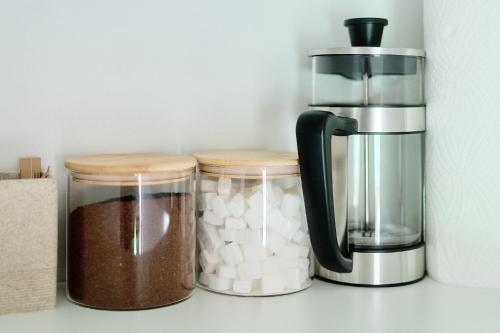 three jars sitting on a counter next to a coffee maker at Your Lutsu Apartment Lux Retro Prime Spot in Viljandi