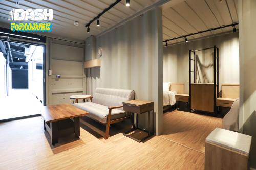 a room with a bed and a couch and a table at Dash Forwaves Hotel in Toucheng