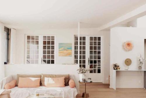 - un salon blanc avec un canapé et quelques fenêtres dans l'établissement Villa Lokeren avec petite vue mer, à Pornichet