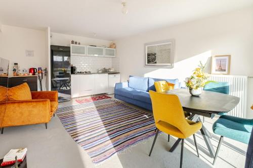 a living room with a table and yellow chairs at Luxury à 10mn du Centre de Paris & Free Parking in Vitry-sur-Seine