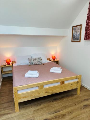 a bedroom with a large wooden bed with two towels at Stara Žaga in Bled