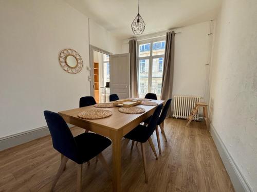 Un comedor con mesa y sillas de madera. en Pause sur la place, en Poitiers