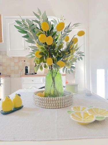 a vase with a bouquet of oranges on a table at Lemon Tree House, Golden Beach in Chrissi Akti