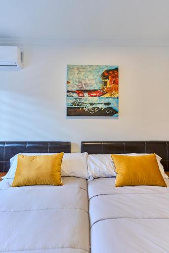 a bedroom with two beds and a painting on the wall at Hotel Villamayor by gaiarooms in Villamayor
