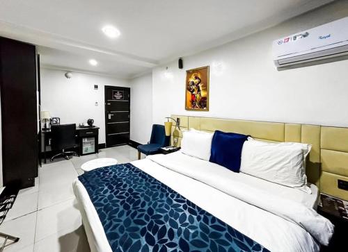 ein Schlafzimmer mit einem großen Bett und einem Schreibtisch darin in der Unterkunft Pasadena hotel and suites in Lagos