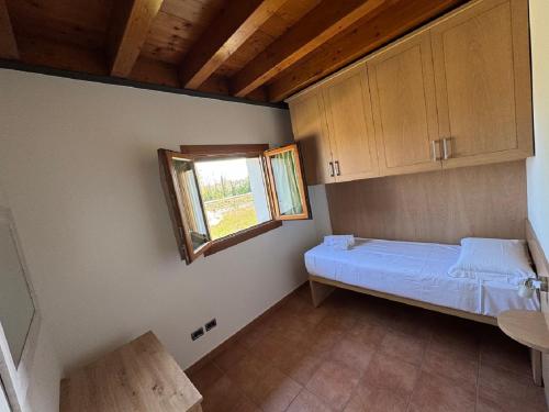 a small room with a bed and a window at Kairos Garda Hotel in Castelnuovo del Garda