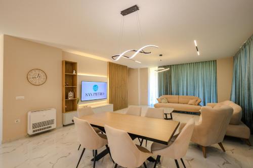 a dining room and living room with a table and chairs at SanPietro Vacation Apartments in Durrës