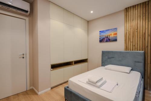 a bedroom with a bed and a mirror at SanPietro Vacation Apartments in Durrës