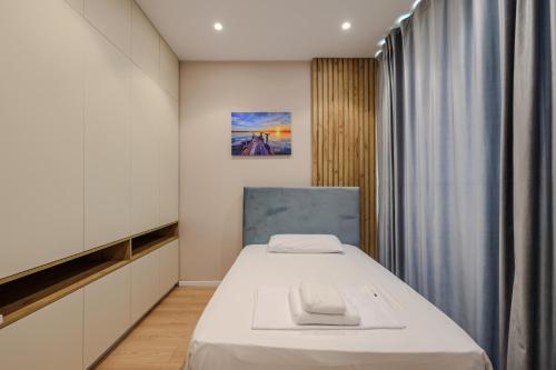 a small room with a bed and a curtain at SanPietro Vacation Apartments in Durrës