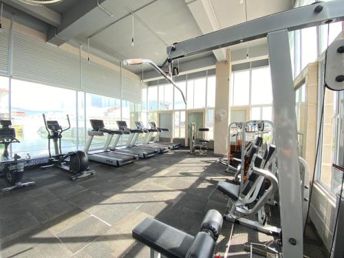 a gym with treadmills and machines in a room with windows at Alltrue Sydney Hotel Batam Center in Batam Center