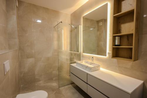 a bathroom with a sink and a mirror at SanPietro Vacation Apartments in Durrës