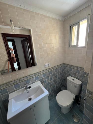 a bathroom with a white toilet and a sink at Balneario Cachucha in Puerto Real