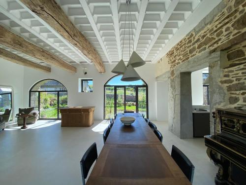 une grande salle à manger avec une longue table et des chaises dans l'établissement Maison haut de gamme 14 couchages - Baie du Mont Saint Michel, à Champeaux