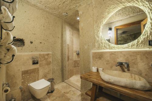 a bathroom with a sink and a toilet and a mirror at Vie Cappadocia - Adults Only in Nevsehir