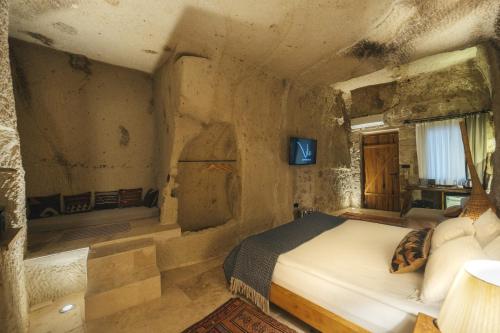 a bedroom with a bed in a stone room at Vie Cappadocia - Adults Only in Nevsehir