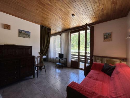 une chambre avec un lit rouge et un plafond en bois dans l'établissement Confort à la montagne, studio spacieux 4 pers., centre Montgenèvre - FR-1-330D-99, à Montgenèvre