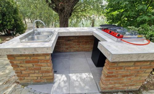 a outdoor kitchen with a sink and a grill at Barrels by the Lake in Priles