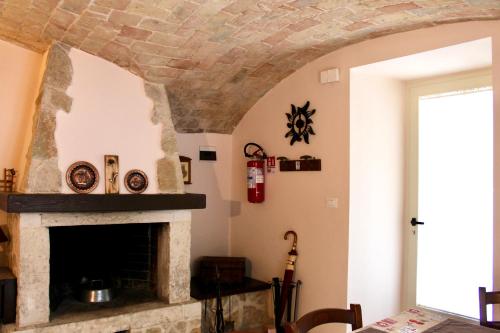 a stone fireplace in a living room with a table at Via Roma 19 in Castel del Monte