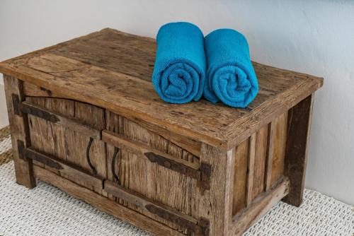 Una caja de madera con dos toallas azules encima. en MANEE Jasmine Pool Villa, Bangrak, Bo Phut, Fisherman's Village, en Bangrak Beach