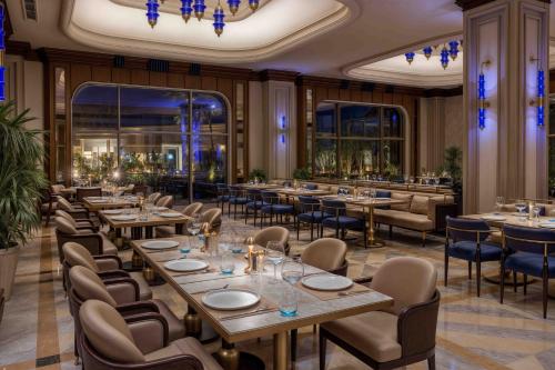 a restaurant with tables and chairs in a room at Merit Royal Gardens Hotel & Casino in İskele