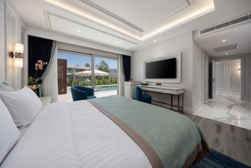 a bedroom with a bed and a desk and a television at Merit Royal Gardens Hotel & Casino in İskele