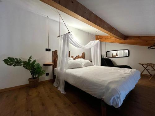 a bedroom with a white bed with a canopy at L Indiana douche sensorielle in Le Muy