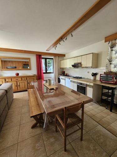 une grande cuisine avec une table et un canapé dans l'établissement Chalet au Mont-Lozère - Chantegrive, à Pourcharesses