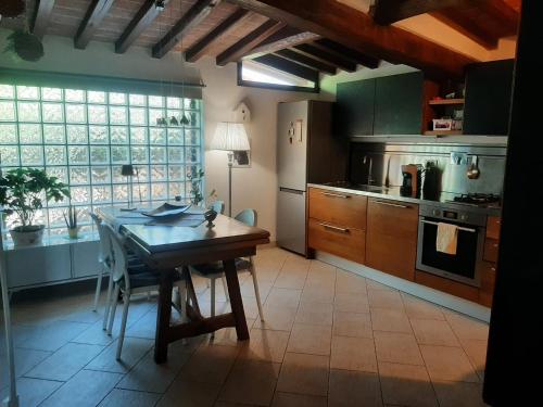 a kitchen with a wooden table and a dining room at La casa di Priscilla in Bucine
