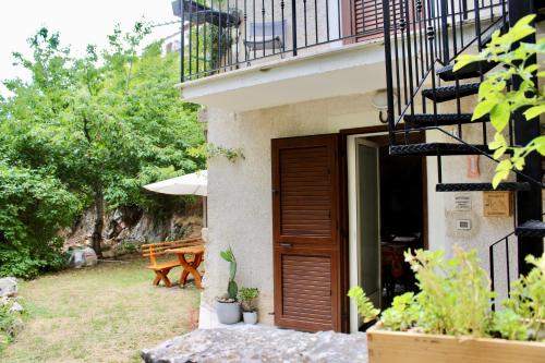 a building with a wooden door and a wooden bench at Via Roma 19 in Castel del Monte