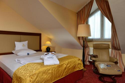a hotel room with a bed and a chair at Best Western Plus Hotel Erb in Parsdorf