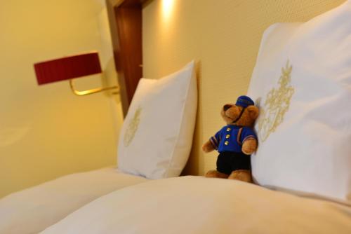 a teddy bear sitting on top of a bed at Best Western Plus Hotel Erb in Parsdorf