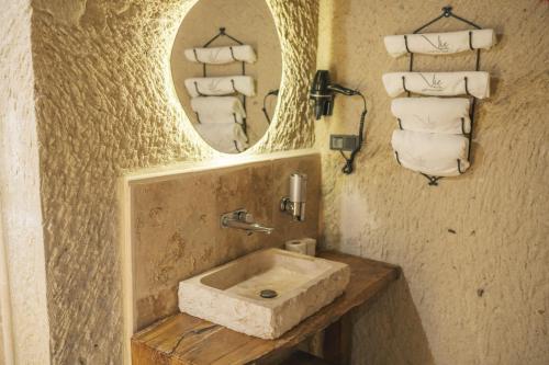 a bathroom with a sink with a mirror and towels at Vie Cappadocia - Adults Only in Nevsehir