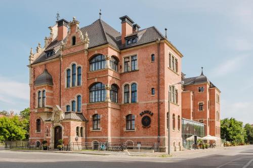 a large brick building on the side of a street at Craft Beer Central Hotel in Gdańsk