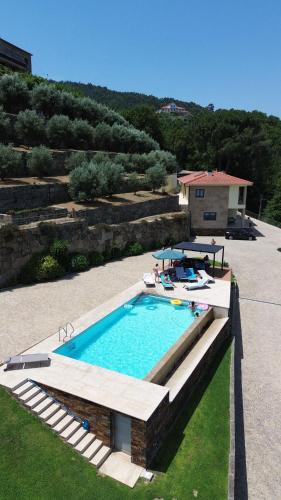 a swimming pool in a yard next to a house at Casa das Oliveiras, o Douro no seu esplendor! in Cinfães