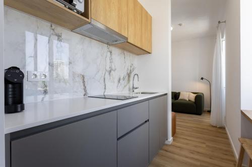 a kitchen with a sink and a counter top at Carmo Suites in Faro