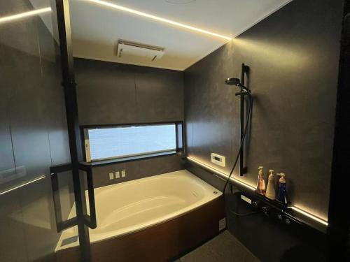a bathroom with a large tub and a window at 梅の由 竹ノ屋 UmenoYu-takenoYa 太宰府 in Dazaifu
