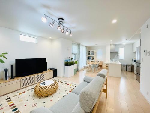 a living room with a couch and a flat screen tv at Alo BnB 7 - Near IKEBUKURO, SHINJUKU, UENO - Self Check in - OYAMA Sta 3min in Tokyo