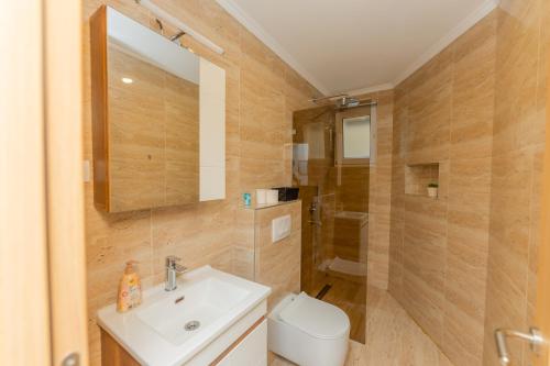 a bathroom with a sink and a toilet and a mirror at Villa Sweet Dreams in Novi Sad