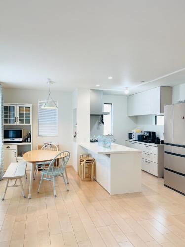 a kitchen with white cabinets and a table and chairs at Alo BnB 7 - Near IKEBUKURO, SHINJUKU, UENO - Self Check in - OYAMA Sta 3min in Tokyo