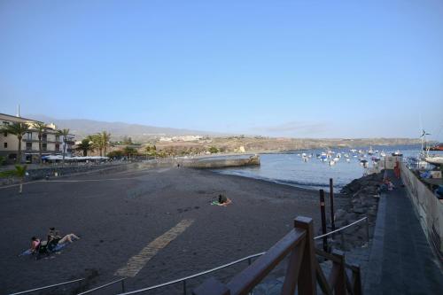 a beach with a bunch of people in the water at Sandy Shores Oasis in Playa de San Juan